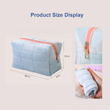 Light blue quilted pouch with pink zipper, shown with measurements and a hand holding the pouch.