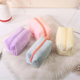 Four colorful quilted pouches on a soft surface