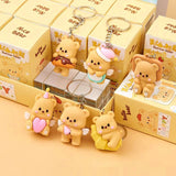Set of cute bear keychains with packaging on a matching yellow background
