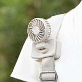 White portable fan attached to a person's shoulder with a blurred green background