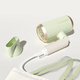 Light green hair dryer with white accents on a light gray background