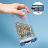 Clear container with blue base filled with green beads, held by a hand against a light blue background.