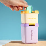 LocknLock container with a hand interacting with it on a blue background