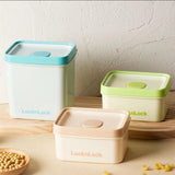 Three LocknLock storage containers on a wooden surface with a light background