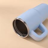 Blue tumbler with a metallic rim on a beige background