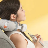 Woman using a neck and shoulder massager with a cartoon character on a yellow background