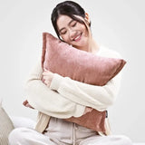Woman holding a pink pillow against a white background