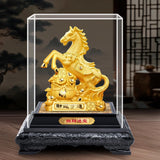 Gold horse statue in a glass display case on a wooden stand with a dark background