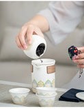 Person pouring tea leaves from a white teapot with wooden accents into a cup.