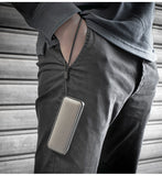 Person wearing a gray hoodie and black pants with a speaker
