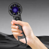 Handheld fan held by a hand