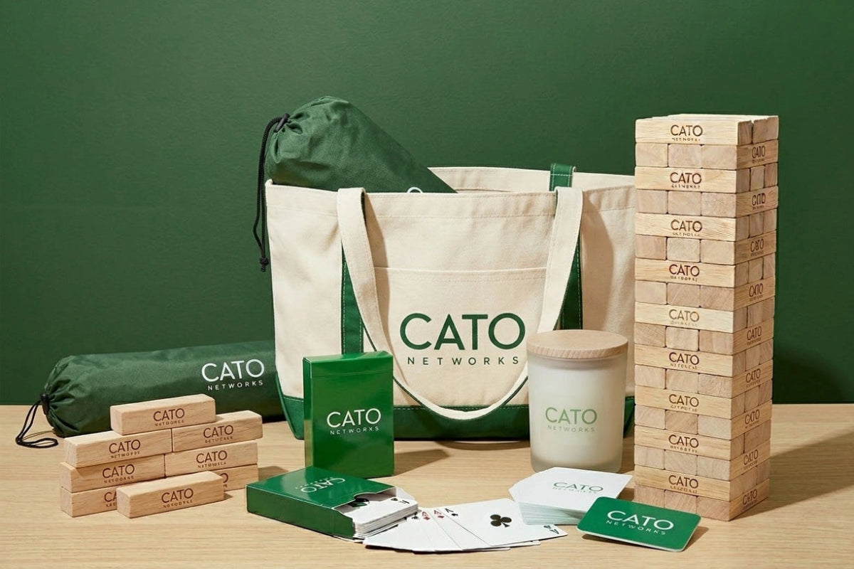 Cato Networks branded items including a tote bag, wooden blocks, and a green box on a wooden surface with a green background.