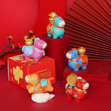 Colorful ceramic oxen figurines on a red background