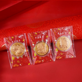 Three gold coins in clear packaging on a red background