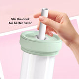 Hand holding a straw over a drink with text 'Stir the drink for better flavor' on a pink background