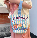 Person holding a striped bag with cartoon characters and the word 'Animal' on it.