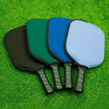 Four colorful Pro-Shield Neoprene Pickleball Paddle Covers in black, green, and blue on a green grass background_Customised Corporate Gifts