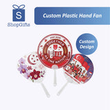 Three custom plastic hand fans with various designs on a white background, featuring the ShopGifts logo.