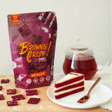 Bag of Brownie Crisp Red Velvet flavor next to a slice of red velvet cake and a cup of tea.