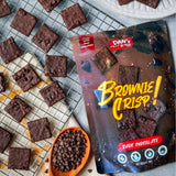 Packaging of Dan's Bites Brownie Crisp with brownies and chocolate chips on a cooling rack.