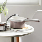 White thermos container with lid on a white surface next to a plant