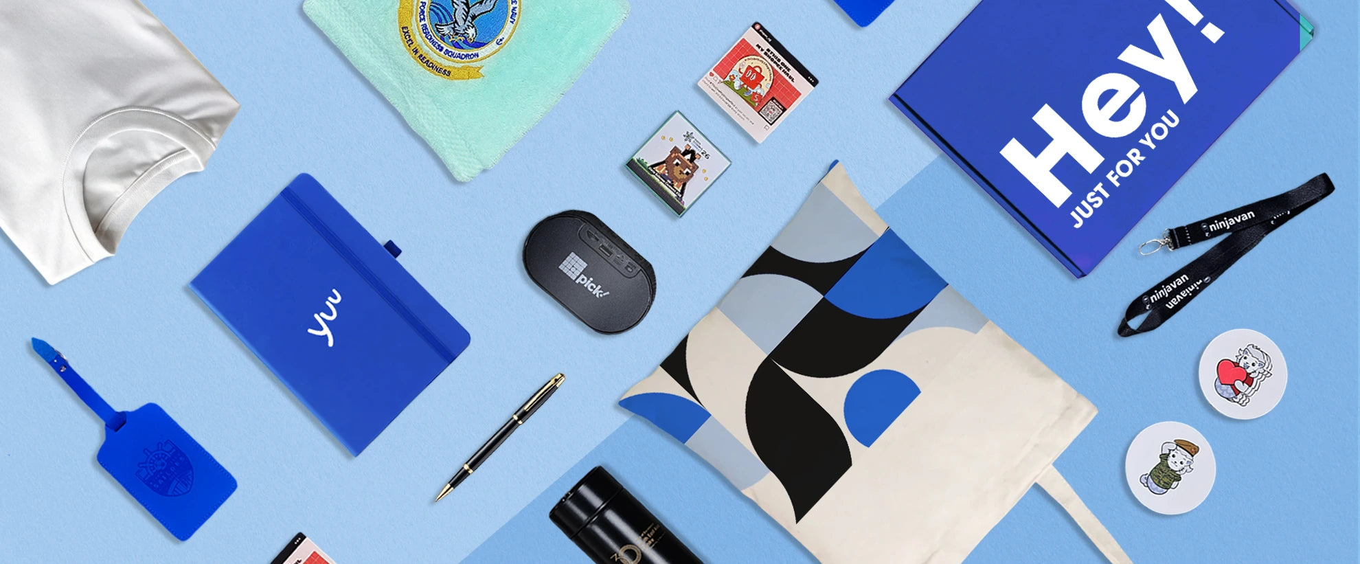 Collection of branded items including notebooks, pens, and phone cases on a blue background