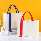 Two tote bags with blue and red handles on a yellow background