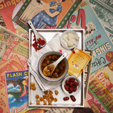 Tray with bowls of food on a colorful vintage magazine background