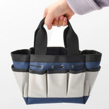 Blue and beige Heavy-Duty Multi-Pocket Oxford Tool Tote with black handles and multiple exterior pockets for garden tools. Gift Shop
