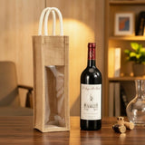 Natural Artisan Jute Wine Carrier with clear window and white rope handles on a wooden surface_Corporate Door Gift