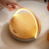 Wooden night light with a hand touching it on a white surface