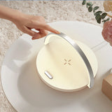 Modern night light on a white surface with a hand pointing at it