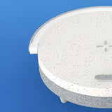 Round white object with gray speckles on a blue background