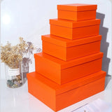 A colorful stack of premium Lift Off Lid Rigid Boxes in various shades including navy, red, orange, pink, and black, featuring a sturdy two-piece telescopic design for high-end gift packaging. corporate gift singapore