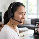 A professional woman participating in a corporate video conference call using the Logitech H151 Stereo Headset, an essential tech gift for remote onboarding kits_customised corporate gifts singapore