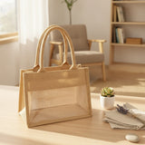 Natural jute tote bag with a clear PVC display window and padded handles on a grassy background_corporate jute bag_corporate door gift