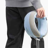 Person holding a blue and gray neck massager against a white background