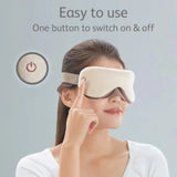 Woman wearing a beige eye mask with a power button, on a light gray background.