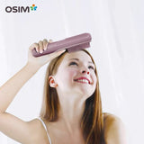 Woman using a pink hairbrush with Osim logo on a white background