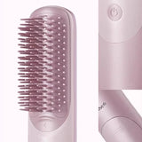 Pink hairbrush with bristle head and power button on a white background