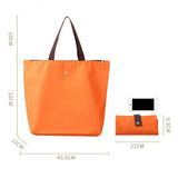 Vibrant orange Premium Foldable Oxford Waterproof Tote Bag hanging on a wooden hook with folded color options_ customised corporate gift singapore
