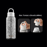 Silver glitter water bottle with white cap on a black background