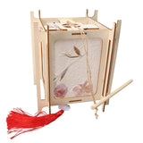 Wooden lantern with floral design and red tassel on a white background