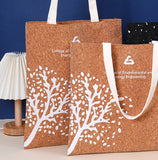 Two cork tote bags with white tree design and text on a blue background