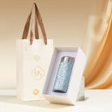 Blue Titanium bottle in a white box with a brown paper bag