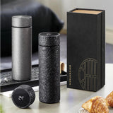 Two black Titanium Hygienic Thermal Bottle with a digital display and a black box on a table.