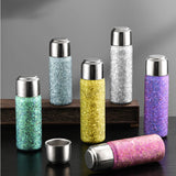 Set of Titanium Trend Bottle (Multiple Colors) with metallic caps on a dark surface.