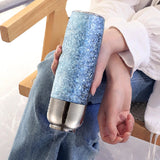 Person holding a blue glittery tumbler