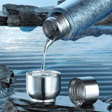 Metallic water bottle pouring water into a metal cup 