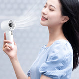 Woman using a handheld white electric fan